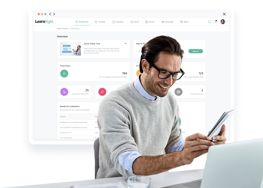 Man using a tablet and laptop with an online learning management system dashboard displayed in the background.