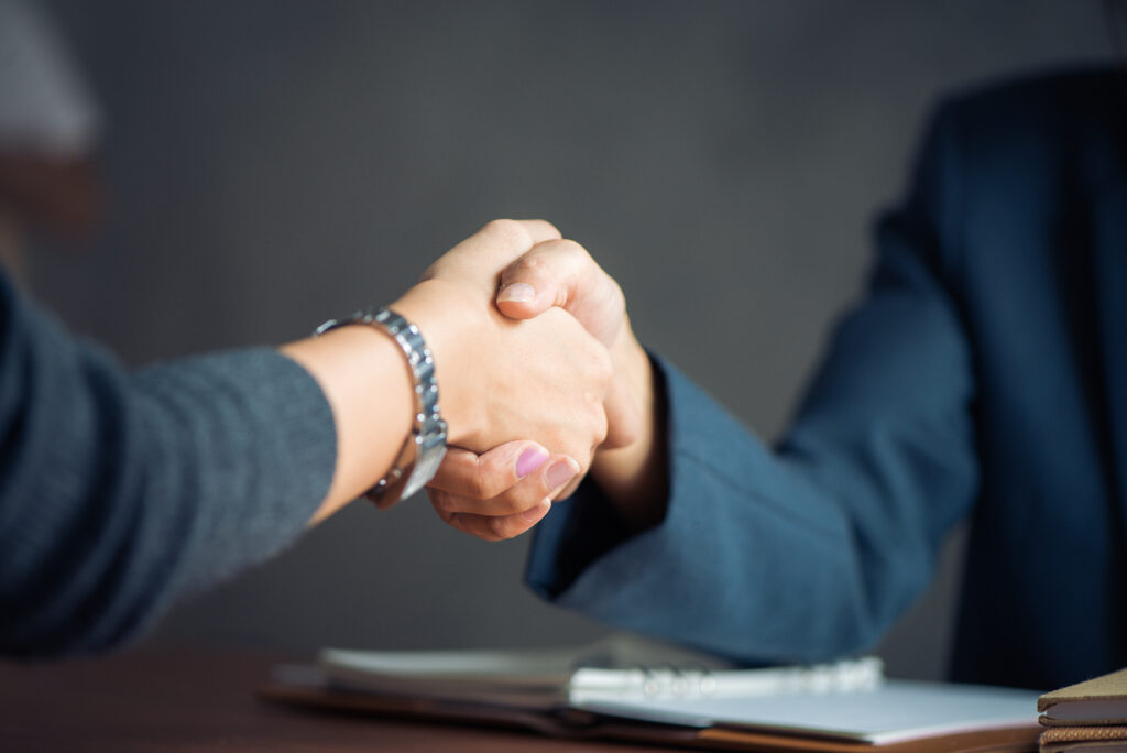 Negotiating business, two people handshaking