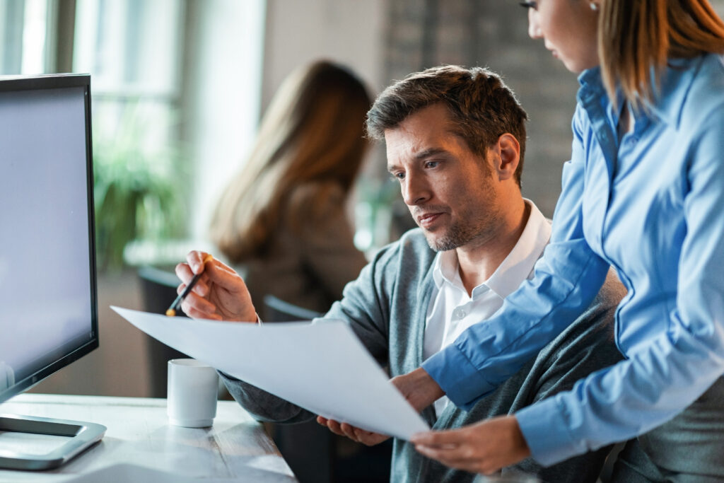 Two business colleagues examining documents while working together in the office.